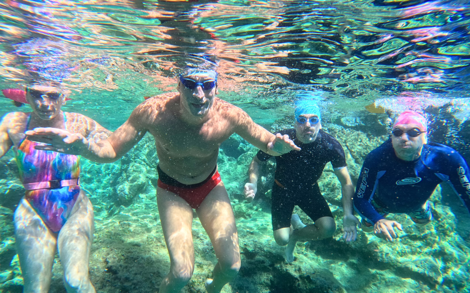 Open water swimmers exploring clear turquoise waters during a guided swim in Greece