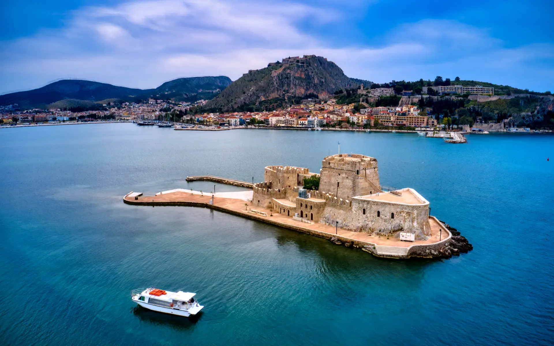 Aerial view of Bourtzi fortress and Nafplio harbor with Palamidi Castle in Greece.