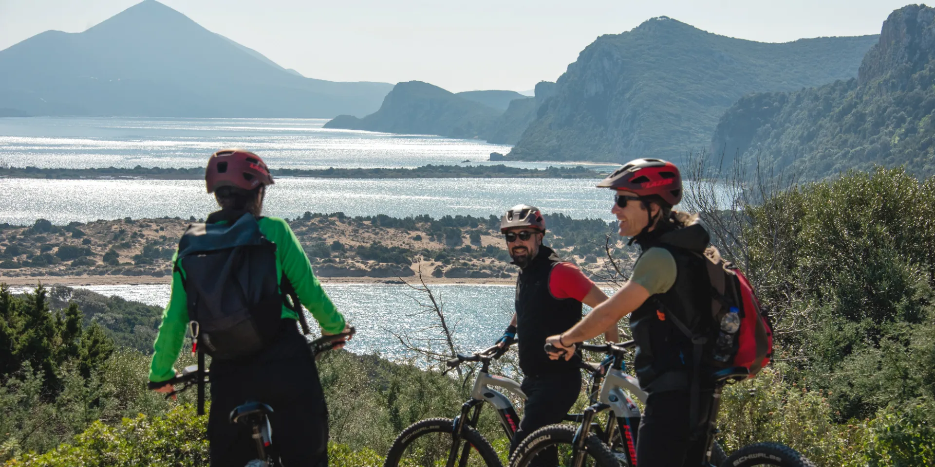 Cyclists on a viewpoint over Navarino Bay and Nestor's Cave, during their e-bike holiday in Southern Greece, Peloponnese.